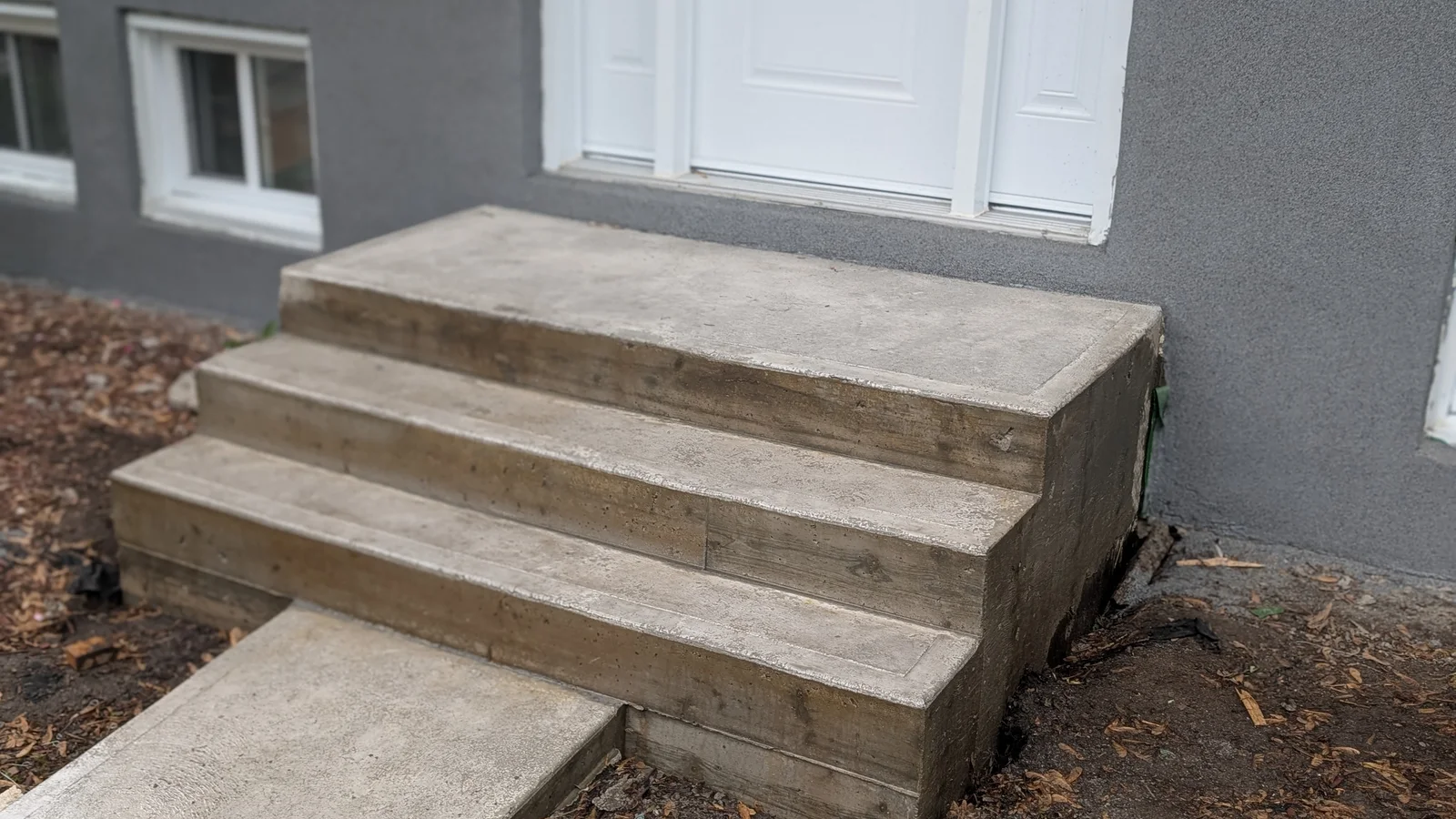 Petit escalier extérieur en béton avec marches et contremarches nouvellement réalisées